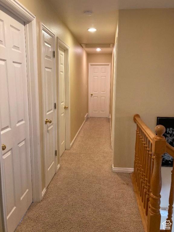 corridor featuring light carpet, an upstairs landing, baseboards, and recessed lighting