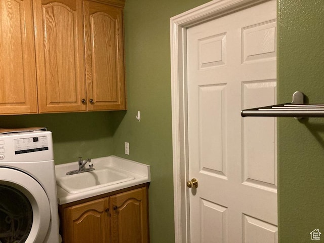 clothes washing area with washer / dryer and cabinet space