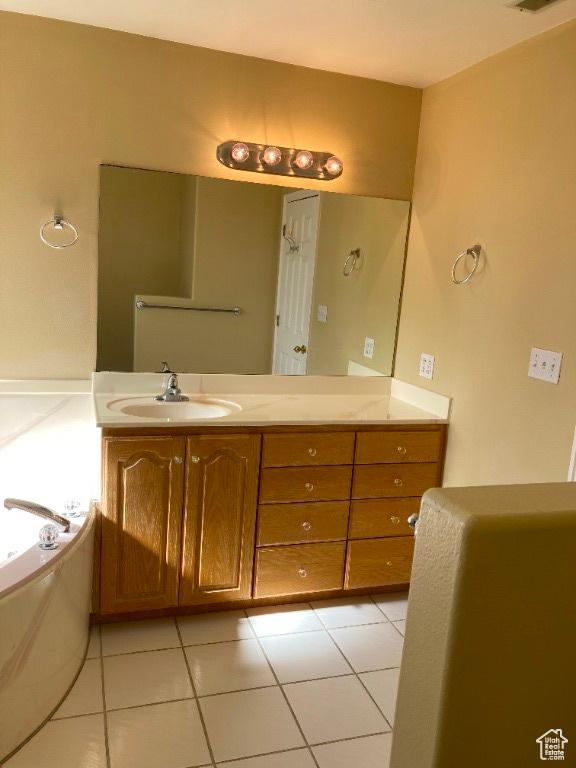 bathroom with vanity, a garden tub, and tile patterned floors