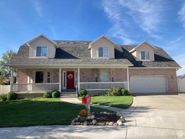 traditional-style house featuring brick siding, covered porch, a garage, and driveway