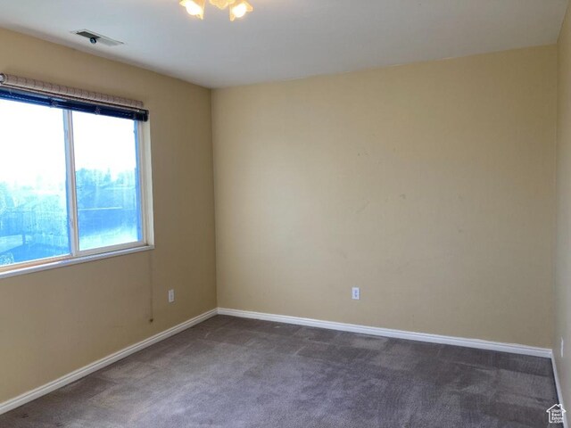 carpeted empty room featuring baseboards