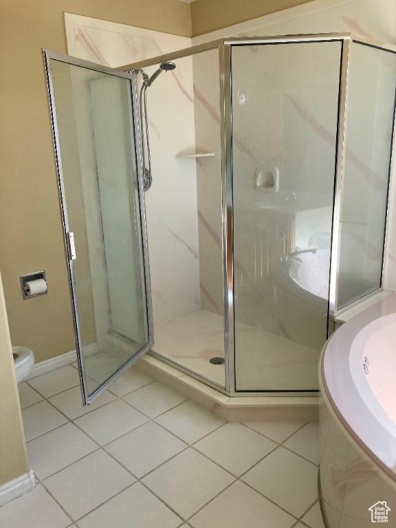 full bath featuring tile patterned flooring, a stall shower, toilet, a bath, and baseboards