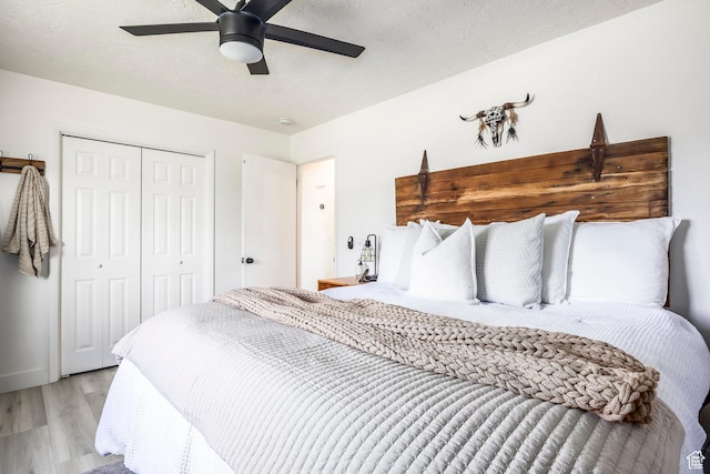 bedroom with light wood-type flooring, a closet, and a ceiling fan