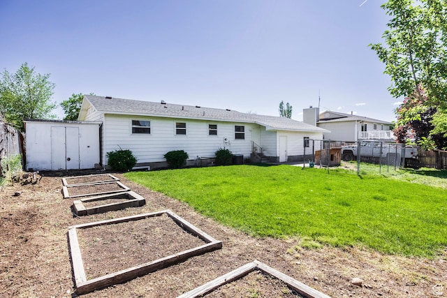 back of property featuring a garden, a storage shed, and an outdoor structure