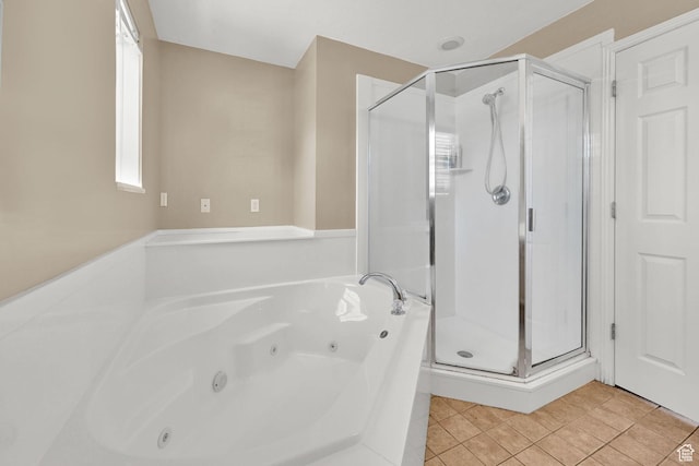 bathroom featuring a jetted tub, a stall shower, and tile patterned floors