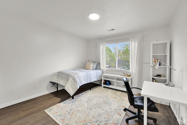 bedroom with a desk, wood finished floors, and baseboards