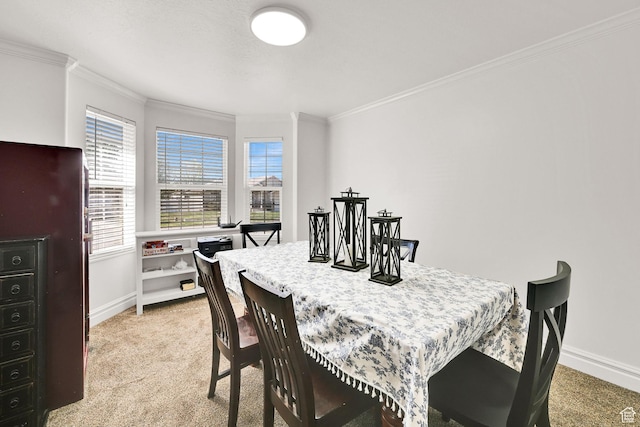 dining room with crown molding, light colored carpet, and baseboards