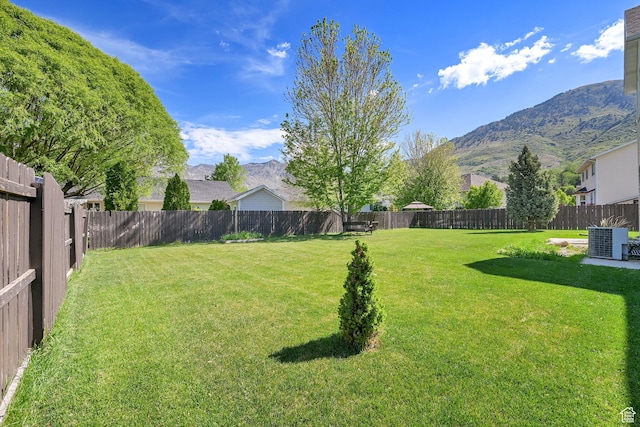 view of yard with a mountain view and central AC unit