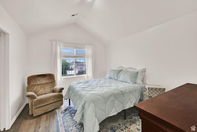 bedroom featuring wood finished floors, vaulted ceiling, and baseboards