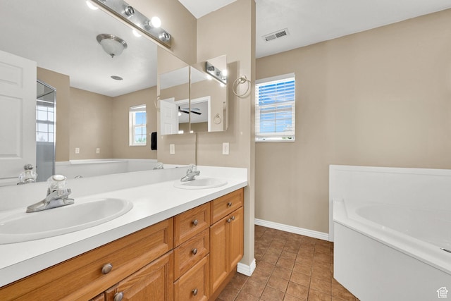 bathroom featuring baseboards, a bath, double vanity, and tile patterned floors