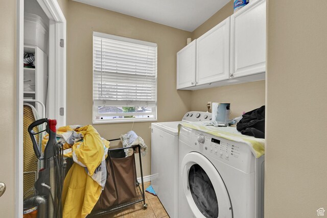 laundry room featuring independent washer and dryer, cabinet space, and light tile patterned floors