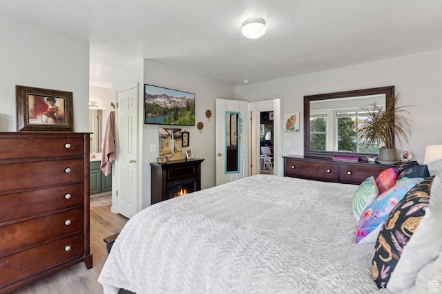1298 E 5875 S, Ogden, UT 84405 - bedroom with light wood finished floors, a lit fireplace, and connected bathroom