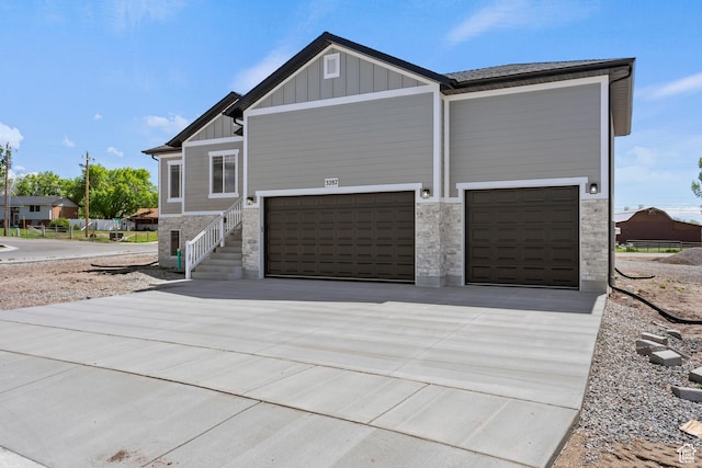 3287 S 4950 W, West Haven, UT 84401 - view of side of property featuring driveway, board and batten siding, stone siding, and a garage