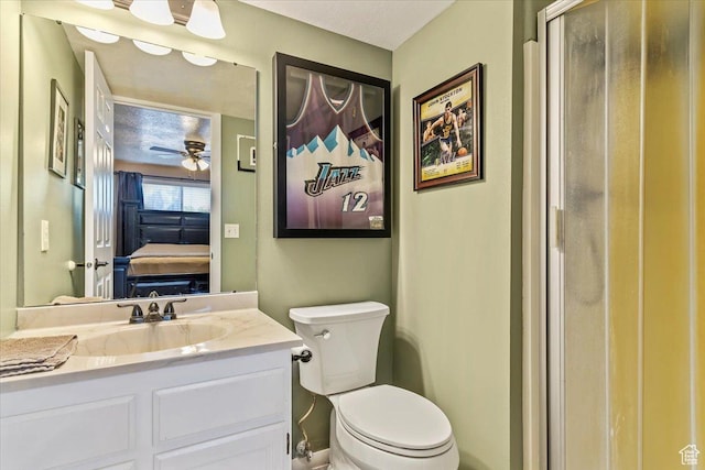 ensuite bathroom featuring vanity, toilet, and ceiling fan