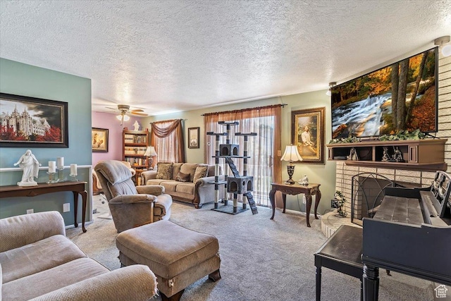 carpeted living area with a fireplace with raised hearth, a textured ceiling, and a ceiling fan
