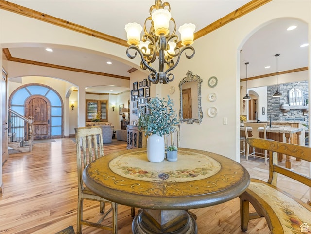dining room with arched walkways, ornamental molding, a chandelier, and recessed lighting
