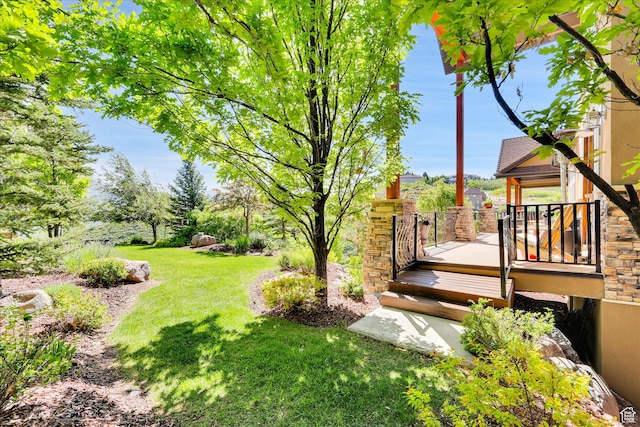 view of grassy yard featuring a wooden deck