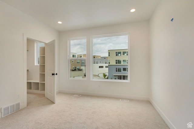 carpeted empty room featuring recessed lighting and baseboards