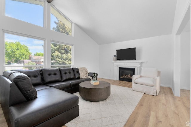 1188 E 300 N, Layton, UT 84040 - living room featuring light wood-type flooring, high vaulted ceiling, baseboards, and a glass covered fireplace