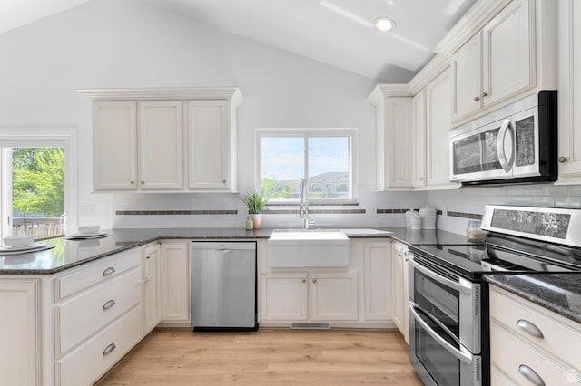1188 E 300 N, Layton, UT 84040 - kitchen with stainless steel appliances, vaulted ceiling, a peninsula, decorative backsplash, and a sink