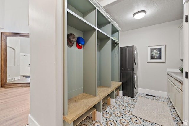 mudroom with baseboards and a textured ceiling