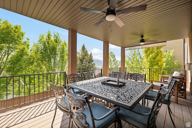 wooden terrace featuring outdoor dining area and a ceiling fan