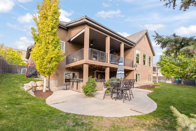 back of house featuring a balcony, ceiling fan, stucco siding, a patio area, and central AC unit