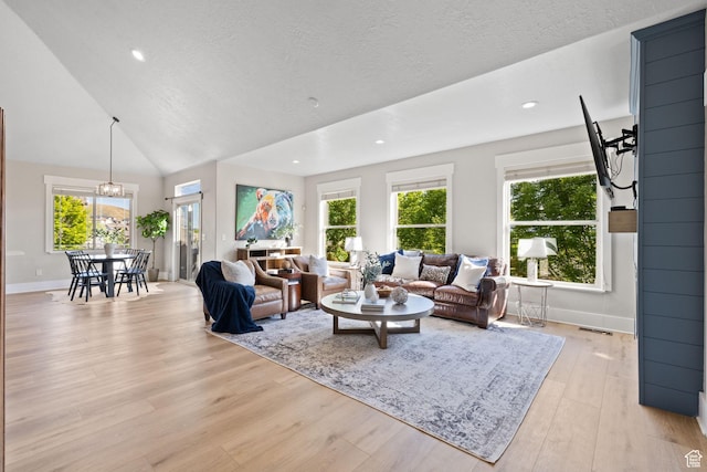 living room featuring light wood finished floors, baseboards, a textured ceiling, and recessed lighting