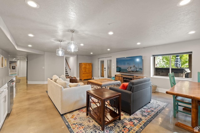 living room with finished concrete flooring, stairs, recessed lighting, a textured ceiling, and baseboards