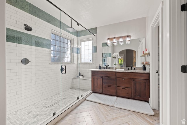 full bath with a stall shower and double vanity