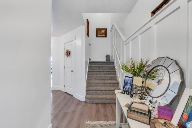 staircase featuring wood finished floors and baseboards