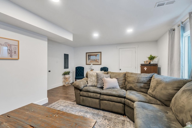 living area featuring recessed lighting, wood finished floors, baseboards, and electric panel