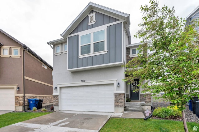 view of front facade featuring stone siding, board and batten siding, an attached garage, and concrete driveway