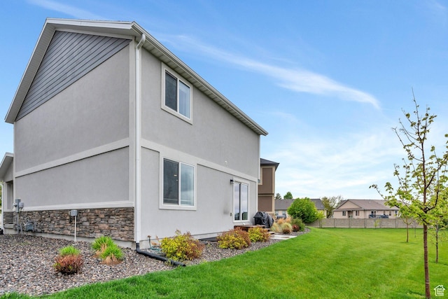 rear view of property with stucco siding and stone siding