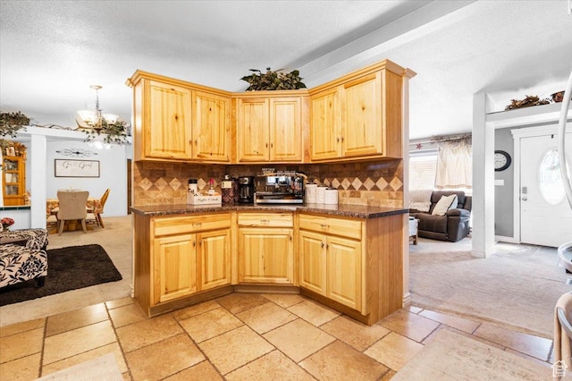 kitchen with light carpet, a chandelier, decorative backsplash, light brown cabinetry, and a textured ceiling