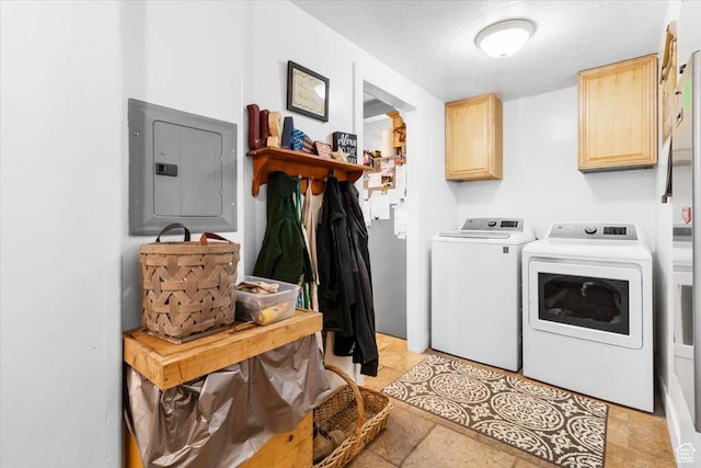 washroom with washer and dryer, electric panel, cabinet space, and a textured ceiling