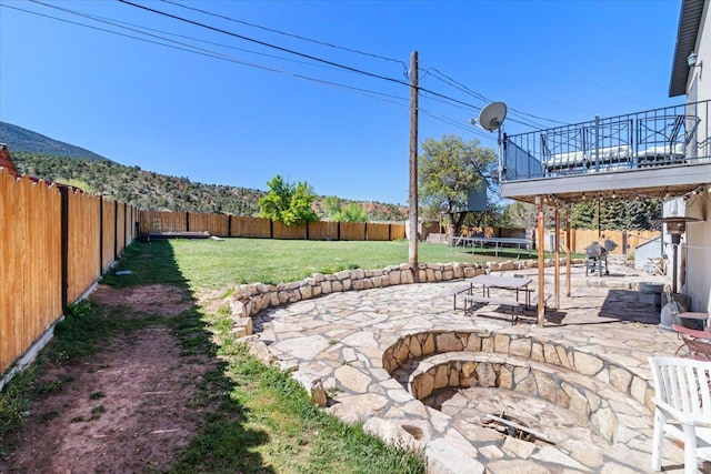 view of yard featuring a trampoline, a patio, and an outdoor fire pit