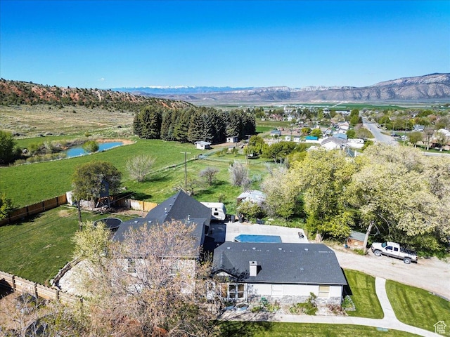 aerial view of property and surrounding area featuring a water and mountain view