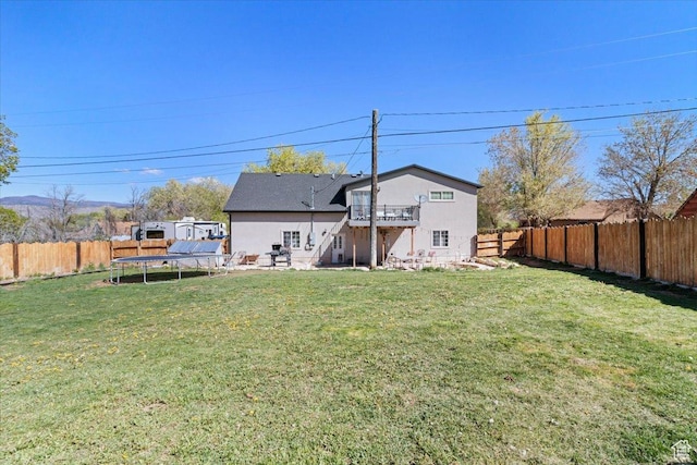 rear view of house with a trampoline and a deck