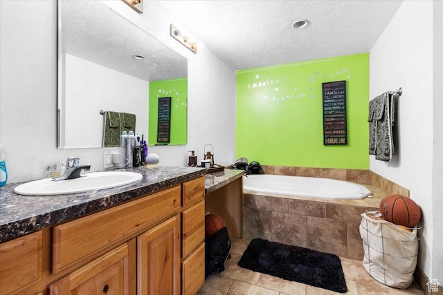 full bathroom with a garden tub, a textured ceiling, and vanity