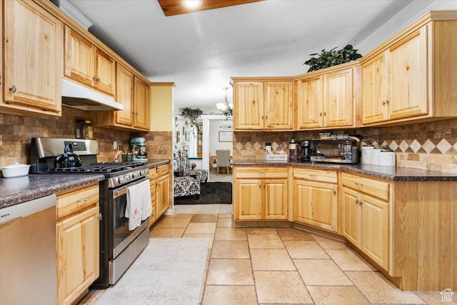 kitchen with stainless steel appliances, under cabinet range hood, decorative backsplash, dark countertops, and light brown cabinets