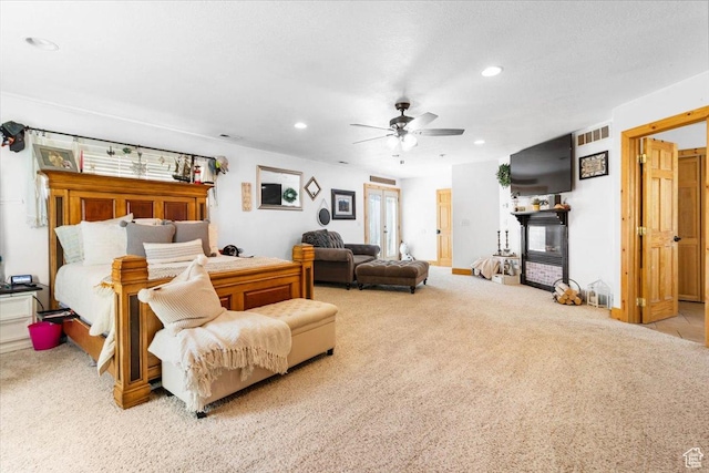 bedroom with carpet, recessed lighting, a ceiling fan, and a glass covered fireplace