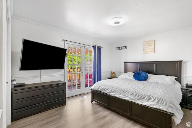 bedroom featuring access to exterior, crown molding, and light wood-style floors