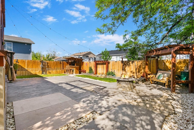 view of patio / terrace with a fenced backyard, a pergola, and an outdoor living space with a fire pit