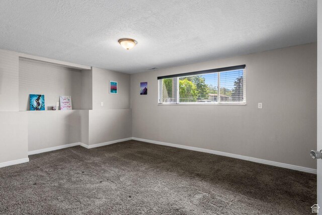 carpeted empty room with a textured ceiling and baseboards