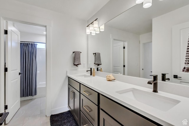 bathroom featuring double vanity and baseboards