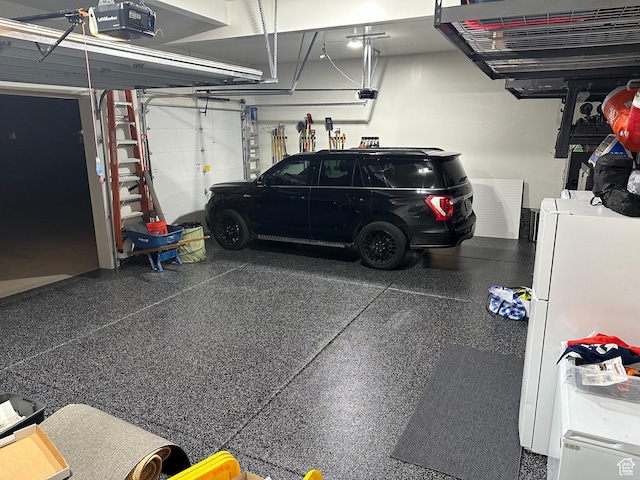 garage with a garage door opener and freestanding refrigerator