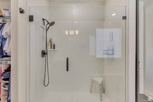 bathroom featuring a shower stall and a spacious closet