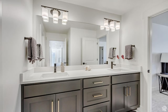full bath featuring double vanity and baseboards