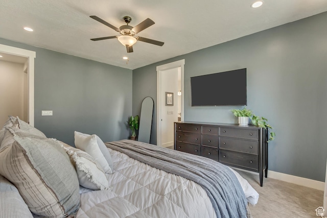 bedroom featuring light colored carpet, recessed lighting, baseboards, ceiling fan, and ensuite bathroom
